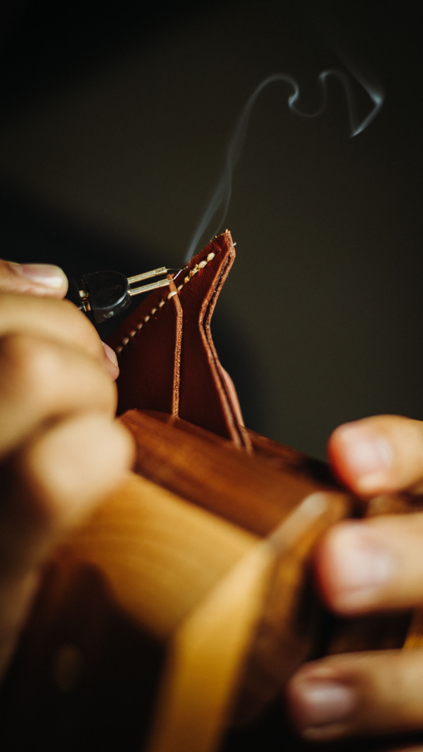 Leather worker shaping a piece of vegetable-tanned hide at a workbench.