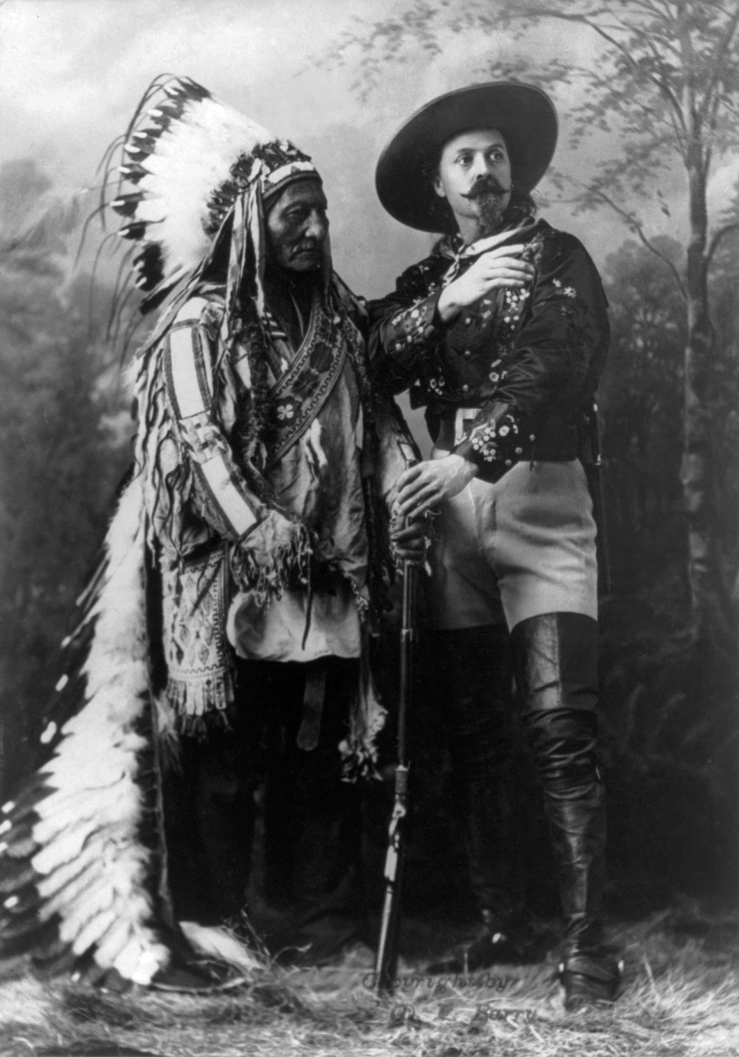 Sitting Bull and Buffalo Bill Cody seated side by side in a studio portrait, 1885.