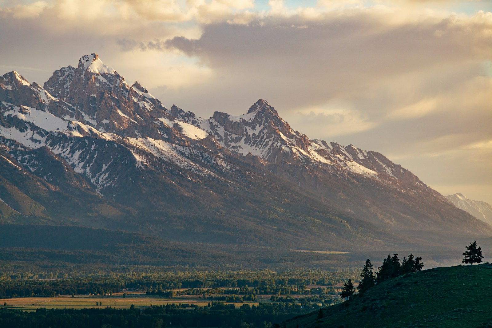 Snow-covered mountain rising above open foothills.