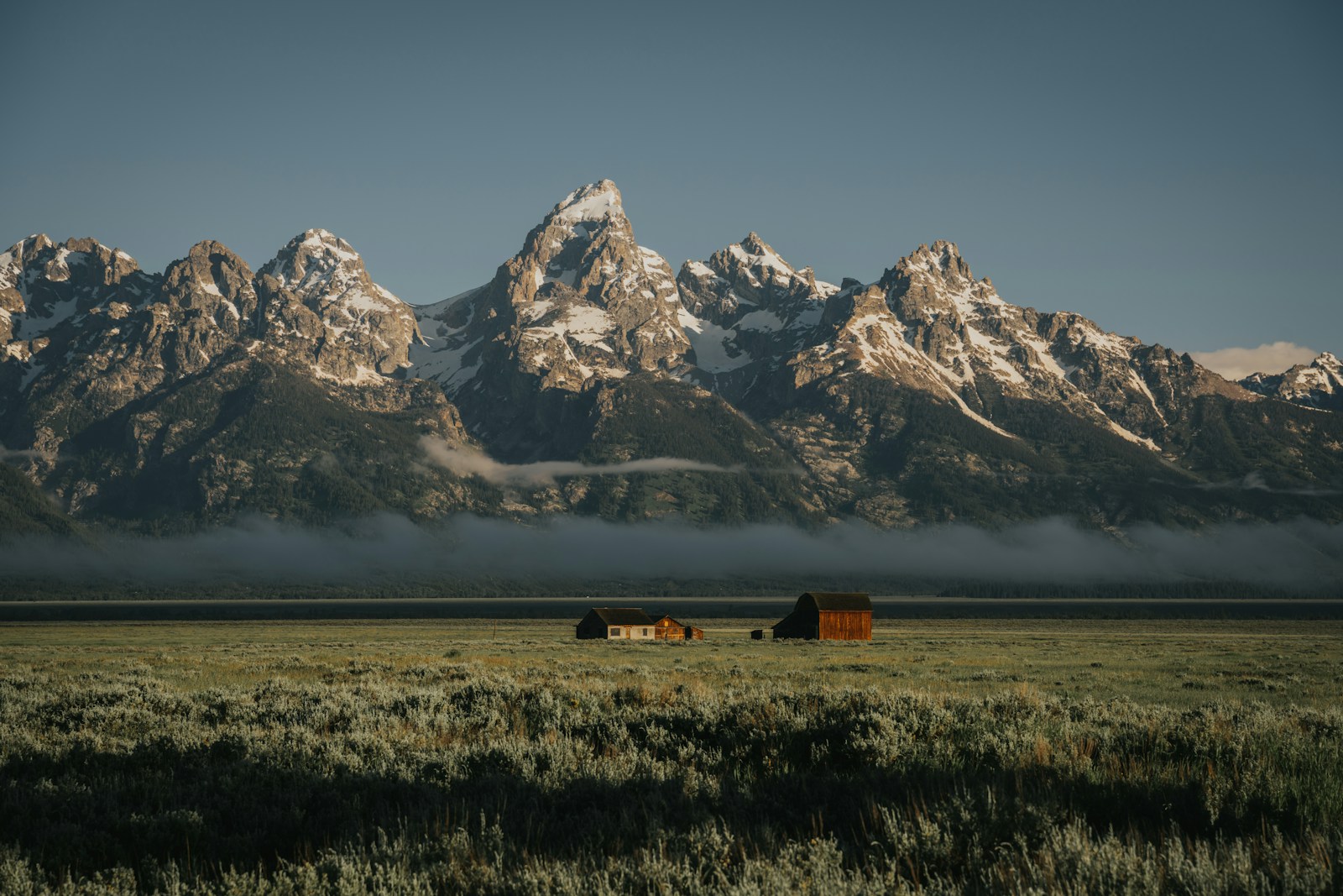 Banded brown and white mountain peaks under a deep blue sky.