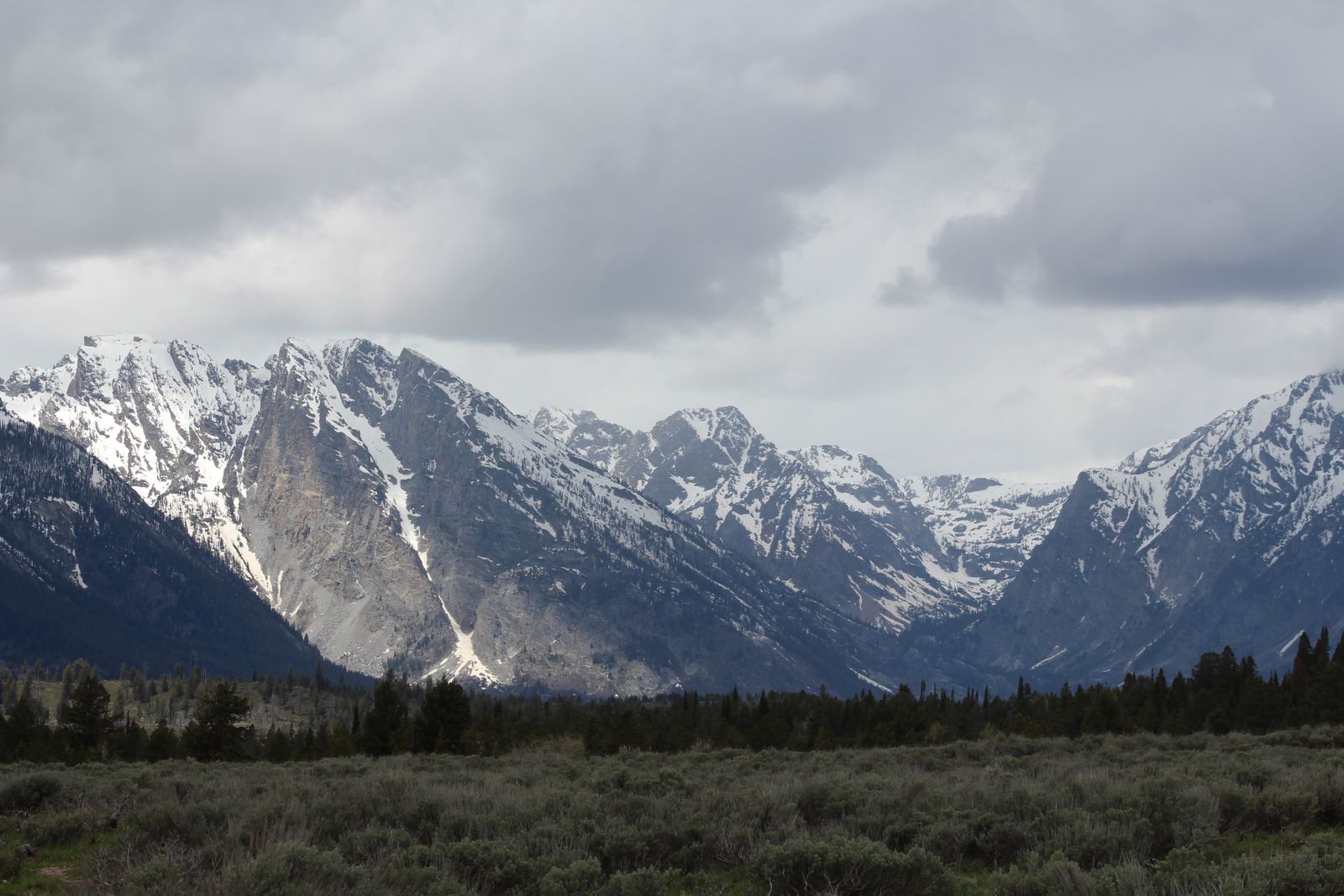 Snow-covered mountain peaks in Wyoming under a winter sky, the high-plains landscape typical of the Park County terrain where Heart Mountain camp was built.