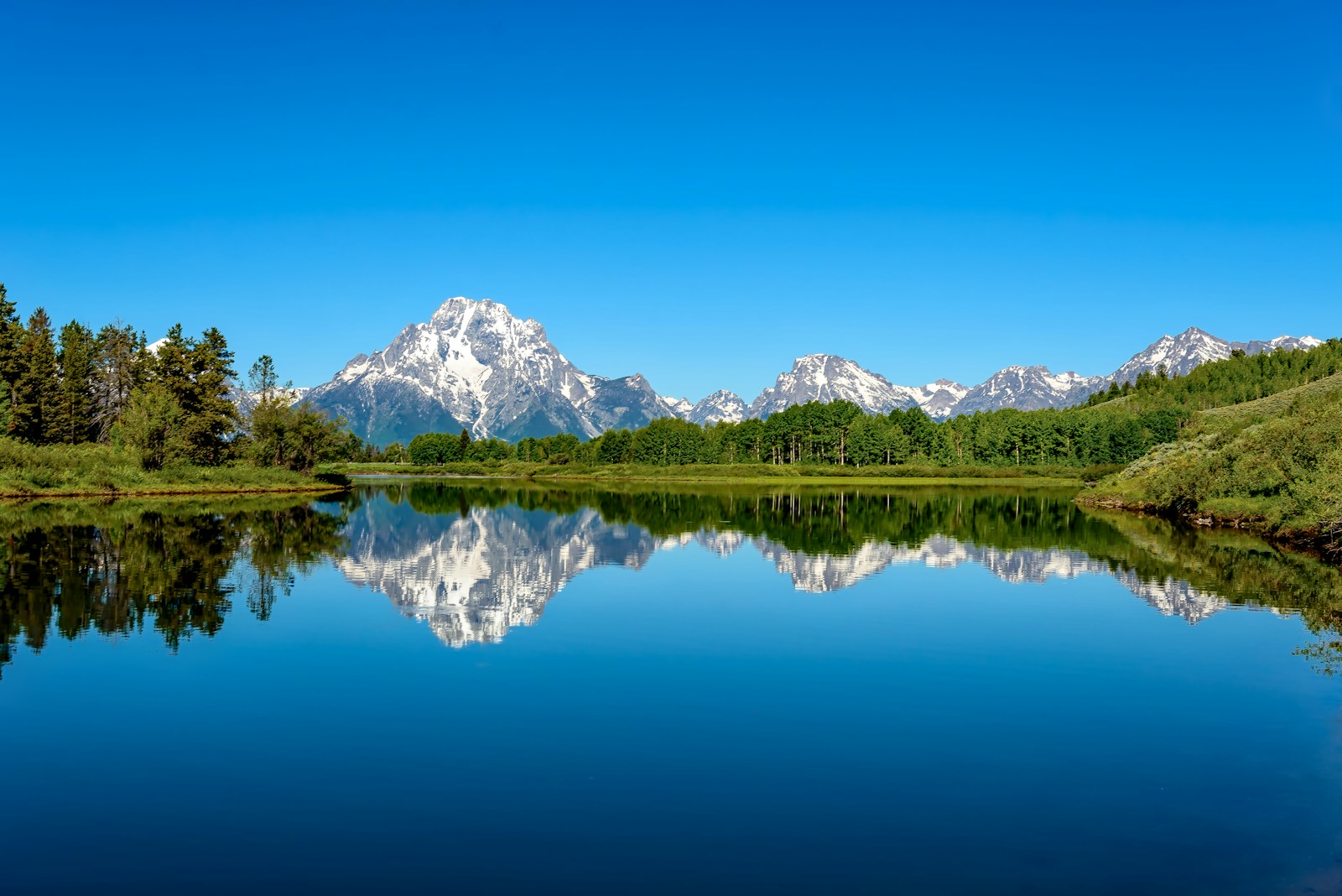 Mountain peaks reflected in the still surface of an alpine lake.